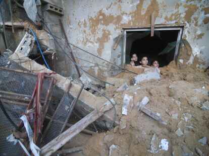 Pal&auml;stinensische Kinder schauen in Rafah im S&uuml;den des Gazastreifens aus einem Fenster, das bei israelischen Luftangriffen zerst&ouml;rt wurde.