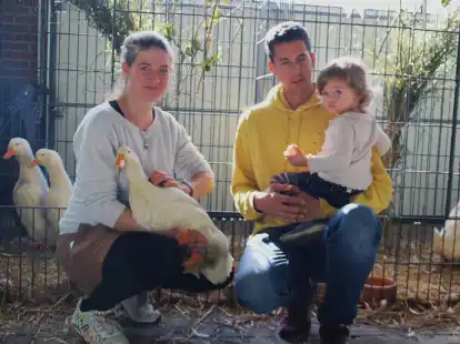 Z&uuml;chten auch Rassegefl&uuml;gel, das vom Aussterben bedroht ist: Larissa Gogolka mit einer Deutschen Pekingente; rechts ihr Mann Daniel, der schwarze Cayugaenten und H&uuml;hner der Rasse Australorps z&uuml;chtet, mit T&ouml;chterchen Olga.