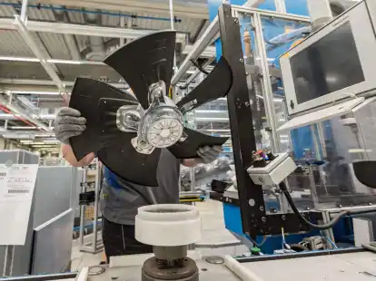 Ein Mitarbeiter eines Herstellers von Ventilatoren und Elektromotoren montiert einen L&uuml;fter.