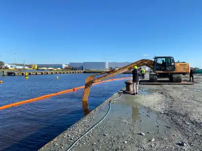 Probebaggerung am sp&auml;ten Dienstagnachmittag: Weil das Hafenwasser so tr&uuml;b ist, muss der Bagger erst einmal &bdquo;ein Gef&uuml;hl&ldquo; f&uuml;r die Lage des Splitts bekommen, sagt NPorts.