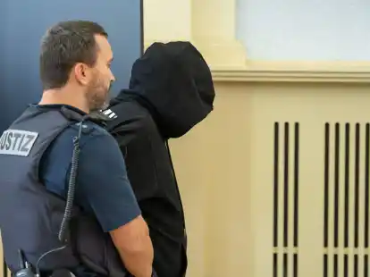 Der Angeklagte (r) wird vor Prozessbeginn in den Gerichtssaal gebracht. Gegen ihn wurde eine lebenlange Haftstrafe verh&auml;ngt.