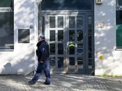 Ein Polizeibeamter geht an der Synagoge an der Brunnenstra&szlig;e 33 in Berlin entlang, die Ziel eines Anschlags war.