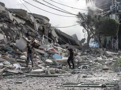 Pal&auml;stinenser inspizieren die Tr&uuml;mmer nach einem israelischen Angriff auf das Viertel Tel al-Hawa im Gazastreifen.