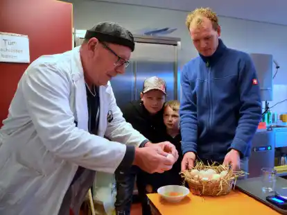 Preisrichter Dieter Sprenkel bewertete nicht nur 55 der 160 ausgestellten Tiere, sondern auch die Eier, die f&uuml;r eine erfolgreiche Zucht schlie&szlig;lich wichtig sind. Finn und Benn sowie der Vorsitzende des Vereins, Torsten Bruns, schauen ihm dabei zu.