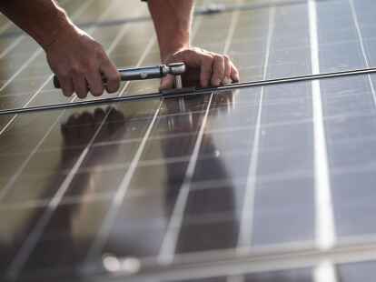 Fachkr&auml;fte montieren Photovoltaikmodule auf dem Dach eines Wohnhauses in Stuttgart.