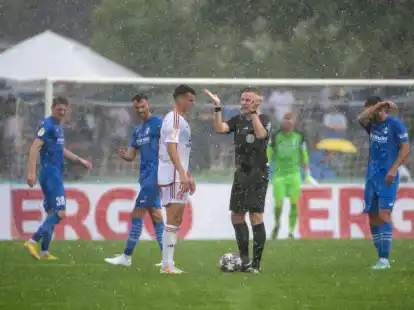 Schiedsrichter Lars Erbst unterbricht das Spiel wegen eines Gewitters.