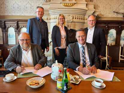 Zur Vertragsunterzeichnung trafen sich am Donnerstag im Kreishaus Jens Knobloch von der EWE und Holger Heymann (vorne) sowie Rolf Clau&szlig;en, Rena Peeks und Harald Hinrichs (hinten) als Vertreter der betroffenen Gemeinden.