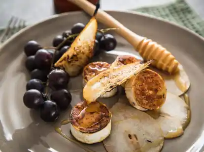 Ein Klassiker unter den Vorspeisen: Die S&uuml;&szlig;e der Weintrauben und der karamellisierten Birnenscheiben balancieren die herzhafte W&uuml;rze von gebratenem Ziegenk&auml;se aus.