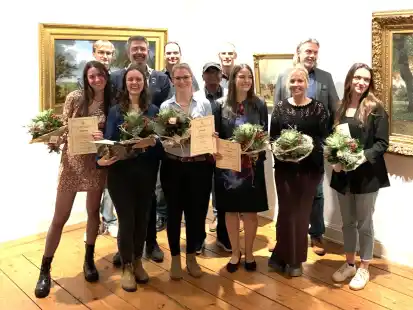 Die Gewinnerinnen und Gewinner des Goldschmiede-Nachwuchswettbewerbes 2023 unter dem Motto &bdquo;nichts Halbes und nichts Ganzes&ldquo; aus den verschiedenen Sieger-Jahrg&auml;ngen im Prinzenpalais, in dem alle Werke ausgestellt worden sind (vorne von links): Lisa Rudelius (1. Lehrjahr/Goldschmiede Wurpts, Bad Zwischenahn), Mareile Saak (1. Lehrjahr/Goldschmiede Speckmann Oldenburg), Sina Herzog (Gesellin/Galerie D'OR Oldenburg), Emily Seyl (4.Lehrjahr/SVN GmbH Nordhorn), Nina Patschke (3. Lehrjahr/Goldschmiede Speckmann Oldenburg) und Antonia Anna Sauff (2. Lehrjahr/Panzerknacker Goldschmiede-L&uuml;beck), im Hintergrund Sponsoren sowie Innungsobermeister Andreas Speckmann (2.v.re.) und der Gesellenpr&uuml;fungsvorsitzende und Lehrlingswart Thomas Kunke (re.).