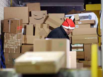 In einer DHL-Zustellbasis wird ein Lkw mit Paketen entladen, um sie auf die Zustellfahrzeuge aufzuteilen.