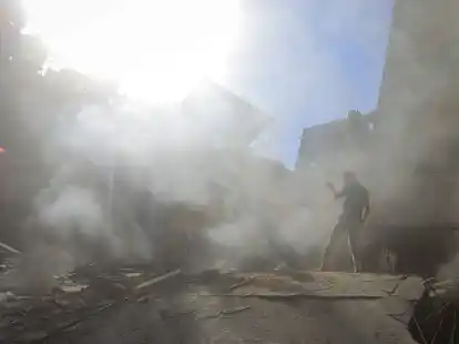 Pal&auml;stinenser und Mitarbeiter des Zivilschutzes suchen in den Tr&uuml;mmern eines zerst&ouml;rten Geb&auml;udes nach einem israelischen Luftangriff auf Chan Junis nach &Uuml;berlebenden.