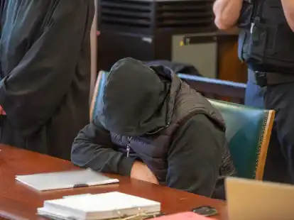 Der 62 Jahre alte Angeklagte sitzt vor seinen Verteidigern im Gerichtssaal.