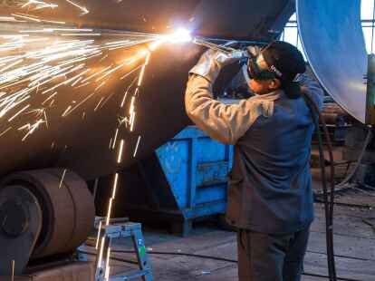 Ein Mann aus Somalia, der zuvor als Schwei&szlig;er ausgebildet wurde, arbeitet in einer Firma an einem Stahlsegment.