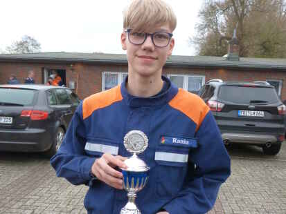 Romke Harms (Jugendfeuerwehr Accum) mit dem von Diedrich Emken gestifteten Pokal f&uuml;r den weitesten Bo&szlig;elwurf.