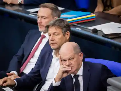 Bundeskanzler Olaf Scholz (SPD, r-l), Wirtschaftsminister Robert Habeck (B&uuml;ndnis 90/Die Gr&uuml;nen) und Finanzminister Christian Lindner (FDP) verfolgen im Deutschen Bundestag die Debatte.