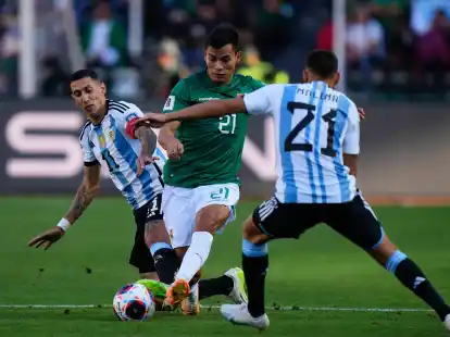 Boliviens Hector Cuellar in Aktion gegen die Argentinier Angel Di Maria (l) und Nahuel Molina (21).