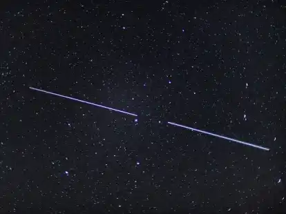 Zwei &laquo;Starlink&raquo;-Satelliten sind als Lichtstreifen am Nachthimmel zu sehen.