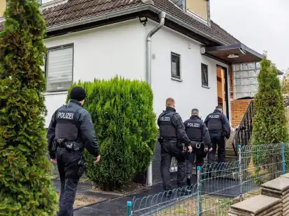 Polizeibeamte durchsuchen ein Haus in einer Wohnsiedlung in Garbsen.