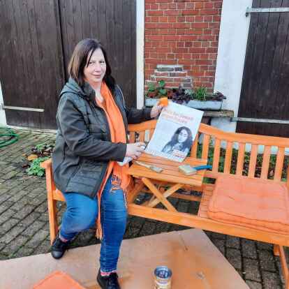 Elke Eilts, Vorsitzende der Kreislandfrauen, auf der orangefarbenen Bank gegen Gewalt an Frauen.
