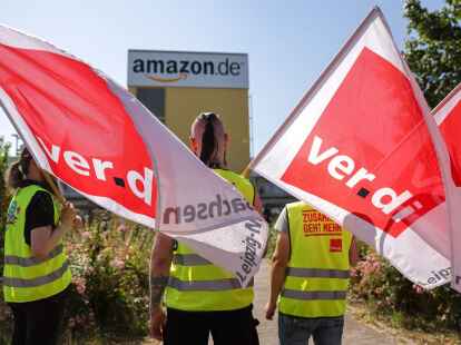 Streikende stehen mit Verdi-Flaggen vor einem Verteilzentrum des Online-H&auml;ndlers Amazon in Leipzig (Archivbild).