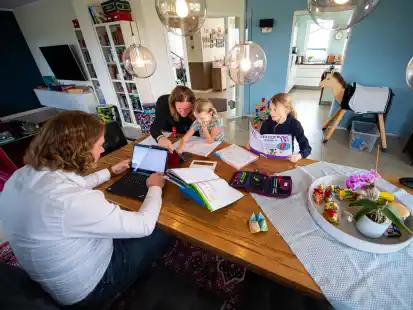 Die siebenjährige Karla und ihre neunjährige Schwester Lotta sitzen im Esszimmer über ihren Hausaufgaben und werden dabei von ihren Eltern, Jens und Stefanie Bergmann, unterstützt.