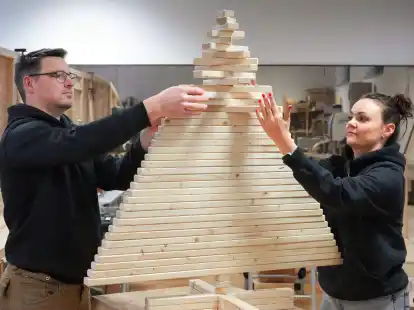 Der Bautechniker Thilo Tolkmitt und Betriebswirtin Ulrike Thunack setzen einen Baum aus Holzlatten zusammen.