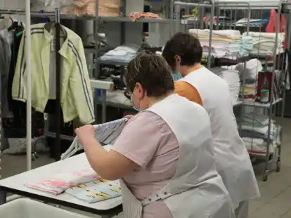 Zwei Frauen arbeiten in der W&auml;scherei der Lebenshilfe Gera e.V und legen dort W&auml;sche zusammen.