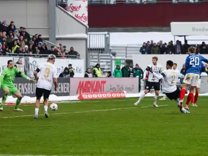 Kiels Fiete Arp (r) trifft zum 2:0 gegen Wiesbadens Torwart Florian Stritzel.