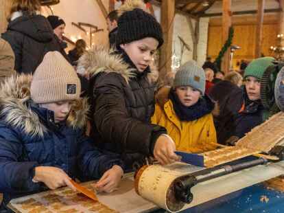 Fleißige Helfer: Die kleinen Besucher holten die Spekulatius-Rohlinge vom Mini-Band der handbetriebenen Maschine.Yvonne Högemann