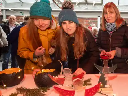 Katharina Zaele (von links), Talea Engelbrecht und Jutta Engelbrecht an einem Stand mit weihnachtlichen Deko-Artikeln.