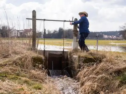 Der W&auml;sserer J&uuml;rgen Zwingel &ouml;ffnet eine Schleuse eines W&auml;ssergrabens im Ortsteil Reichelsdorf: Die Traditionelle Wiesenbew&auml;sserung ist von der Unesco zum immateriellen Kulturerbe ernannt worden.