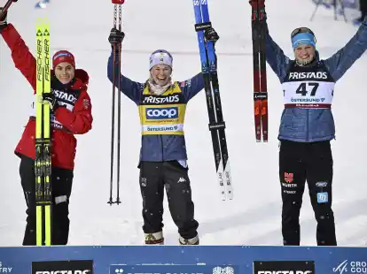 Victoria Carl (r) stand hinter Siegerin Jessie Diggins (M.) und Heidi Weng auf dem Podest.
