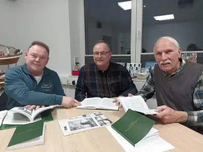 Was ist in Blomberg in den vergangenen Jahrzehnten geschehen? Das ist in der Ortschronik zu lesen, die Dr. Heiko Klaa&szlig;ens (von links), B&uuml;rgermeister Werner Ihnken und Herbert B&ouml;&ouml;k zeigen.
