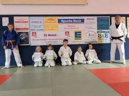 Trainerhelfer Jonah Theevs B&uuml;scher (5. Kyu/oranger G&uuml;rtel) und die Pr&uuml;flinge Mara Schmedding, Telma Klug, Mattis Reich, Johanna Engelhardt, Juri Engel sowie Trainer und Pr&uuml;fer G&uuml;nter Zunder (1. Dan).