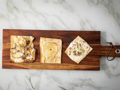 Wer sich nicht entscheiden mag, kann die Flammkuchenst&uuml;cke ganz unterschiedlich belegen: Einen Teil mit Speck und Zwiebel, einen weiteren mit Ziegenk&auml;se und Birne sowie den dritten mit Apfel, Zimt und Zucker.