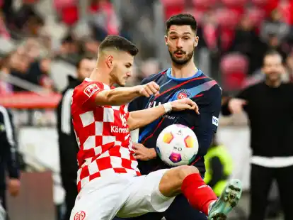 Der Mainzer Tom Krauss (l) liefert sich mit Heidenheims Tim Kleindienst einen Zweikampf um den Ball.