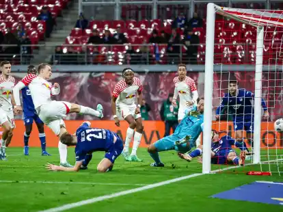 Leipzigs Lukas Klostermann (l) trifft gegen Hoffenheims Torwart Oliver Baumann zum 1:0.