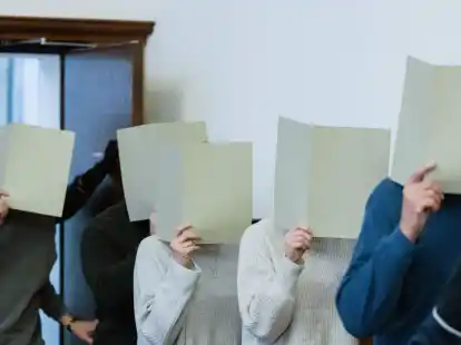 Die f&uuml;nf angeklagten Polizeibeamtinnen und -beamten kommen in den Gerichtssaal des Landgerichts Dortmund