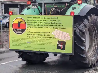 &bdquo;Die jetzige Regierung t&ouml;tet die BRD&ldquo;: An diesem Trecker, der an der Stra&szlig;e &bdquo;Damm&ldquo; in Oldenburg f&auml;hrt, ist ein Plakat mit verschw&ouml;rungsideologischen Symbolen und Botschaften angebracht.