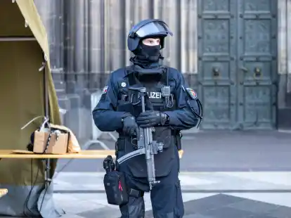 Vor dem Pontifikalamt im K&ouml;lner Dom zum Jahresabschluss mit Kardinal Woelki wird das Domumfeld von Einsatzkr&auml;ften der Polizei mit Maschinenpistolen stark bewacht.