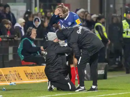 Kiels Fiete Arp wird w&auml;hrend der Partie gegen Hannover 96 am Spielfeldrand behandelt.