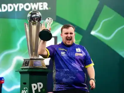 Luke Littler jubelt mit dem Pokal f&uuml;r den zweiten Platz.