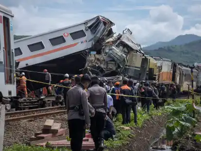 Rettungskr&auml;fte inspizieren die Zugwracks nach dem Zusammensto&szlig; in Indonesien.