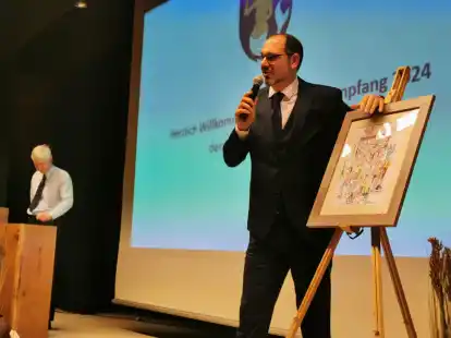 Wochenblatt-Redakteur Sebastian Urbanczyk und Wieland Rosenboom (hinten) bei der Versteigerung des Wimmelbildes.