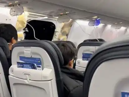 Passagiere sitzen in der Boeing 737-9 Max in der N&auml;he des abgerissenen Kabinenteils samt Fenster.