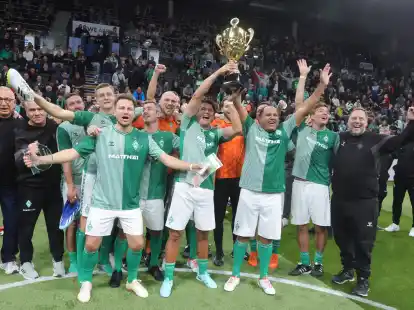 Hatten sichtlich Spaß am gemeinsamen Kicken und Gewinnen: Die Altstars von Werder Bremen mit ihrer Trophäe.