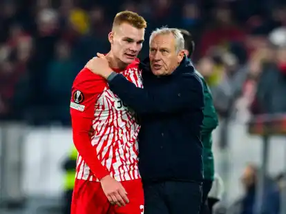Freiburgs Philipp Lienhart (l) klatscht mit Trainer Christian Streich (r) nach einer Auswechslung ab.