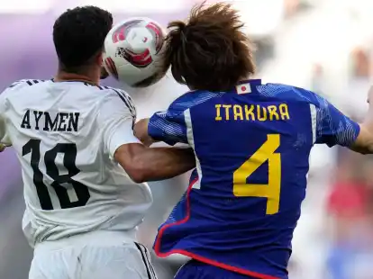 Iraks Aymen Hussein (l) und Japans Kou Itakura im Zweikampf um den Ball.