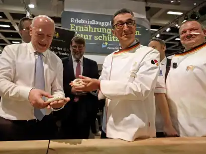 Bundesagrarminister Cem &Ouml;zdemir und Berlins Regierender B&uuml;rgermeister Kai Wegner formen Brezeln beim Er&ouml;ffnungsrundgang &uuml;ber das Messegel&auml;nde der Gr&uuml;nen Woche.