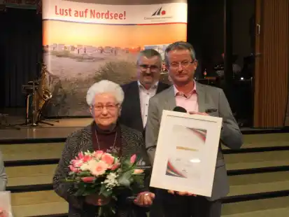 Beim Neujahrsempfang in Carolinensiel wurde Anne Hallen geehrt. Rolf Clau&szlig;en und Simon L&uuml;bben gratulierten.